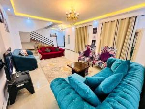 uma sala de estar com um grande sofá azul e cadeiras em فيلا مفروشة بالكامل em Naj‘ al Aḩwāl