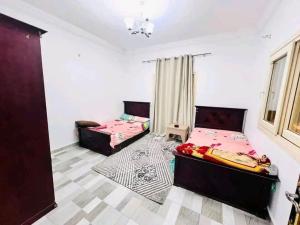 um quarto com duas camas e um sofá em فيلا مفروشة بالكامل em Naj‘ al Aḩwāl