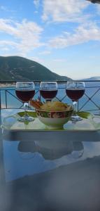 un tavolo con due bicchieri di vino e una ciotola di cibo di Aphrodite studio a Póndi