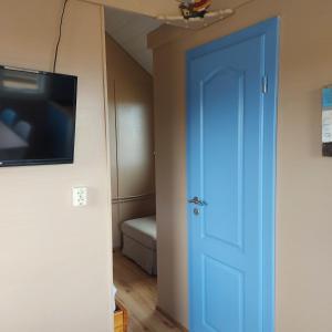 a blue door in a room with a bed at Ofanleiti Cottages in Vestmannaeyjar