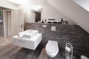 a bathroom with a white sink and a toilet at Apartment HH West modern und komfortabel in Hamburg