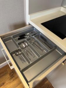 a kitchen with an open drawer with utensils at Alliance Palace Batumi in Batumi