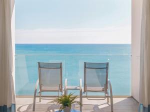 dos sillas sentadas en un patio cerca del océano en Hotel Benalmadena Beach, en Benalmádena