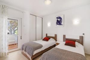 Dos camas en una habitación con ventana. en Townhouse Ramas, en Vale do Lobo