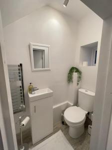 biała łazienka z toaletą i umywalką w obiekcie Pheasants Crossing - luxurious and cozy cottage in peaceful rural location w mieście Almondbury