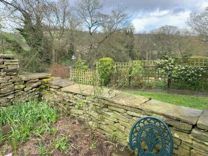 a garden with a stone fence and a stone wall at Pheasants Crossing - luxurious and cozy cottage in peaceful rural location in Almondbury