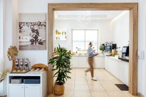 una donna che entra in una cucina con la porta aperta di Hotel Gambrinus Mare a Cattolica