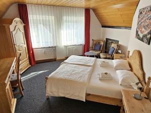 a bedroom with a bed and a desk and a chair at Hotel Hirsch Günzburg in Günzburg