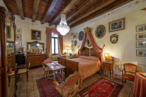 1 dormitorio con 1 cama, mesa y sillas en Relais Castello Bevilacqua en Bevilacqua