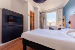 a bedroom with a large bed with a tv on the wall at ibis Nice Centre Notre Dame in Nice