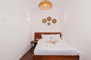 una camera con letto bianco e testiera in legno di Santorini Rooftop Hot Tub Suite with Panoramic Views ad Akrotírion