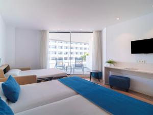 a hotel room with two beds and a flat screen tv at Spirit Hotel Benalmadena Beach in Benalmádena