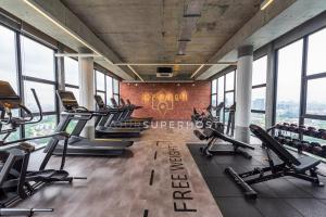 a gym with rows of treadmills and exercise machines at Millerz Square Near MidValley by YourSuperhost in Kuala Lumpur