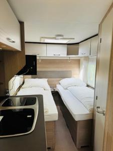 a small room with two beds and a sink at Reisemobil Zentrum Berlin in Berlin