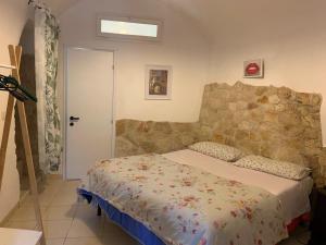ein Schlafzimmer mit einem Bett und einer Steinmauer in der Unterkunft Charming Old Town House in Bari