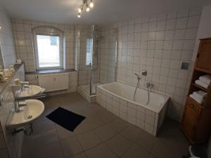 a bathroom with a tub and a sink and a bath tub at Hotel Hirsch Günzburg in Günzburg