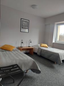 1 dormitorio con 2 camas, mesa y ventana en Hostel Relaks, en Olsztyn