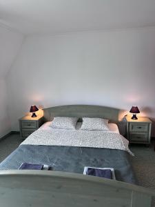 1 dormitorio con 1 cama grande y 2 mesitas de noche en Éden Panzio en Bük