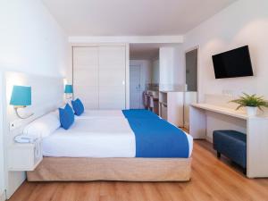 a hotel room with a large bed and a television at Spirit Hotel Benalmadena Beach in Benalmádena