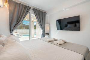 a bedroom with a large bed with towels on it at Punta Mare Villa 3 in Karpathos Town