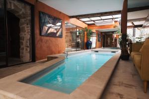 a large swimming pool with blue water in a building at Artishow in L'Isle-sur-la-Sorgue