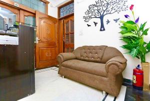 una sala de estar con sofá y un árbol en la pared en ASR Guest House, Janakpuri, New Delhi, en Nueva Delhi