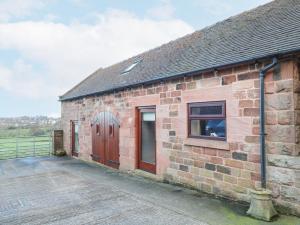 a brick building with a door and a window at Roaches View Barn in Stoke on Trent