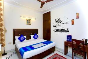 1 dormitorio con cama con almohadas azules y escritorio en ASR Guest House, Janakpuri, New Delhi, en Nueva Delhi