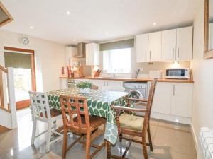 a kitchen with a table and chairs in a kitchen at Roaches View Barn in Stoke on Trent