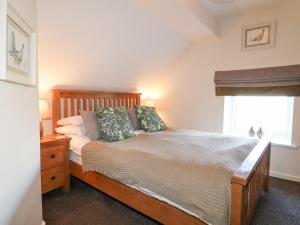 a bedroom with a wooden bed with a window at Roaches View Barn in Stoke on Trent