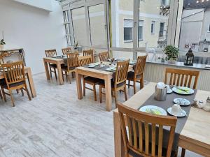una sala da pranzo con tavoli e sedie in legno di Hotel Hirsch Günzburg a Günzburg