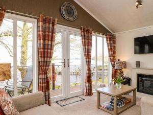 a living room with a fireplace and sliding glass doors at Shoreside Lodge in Bowness-on-Windermere