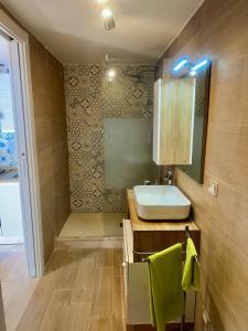 un baño con lavabo y espejo en Sunrise Home, en Letojanni