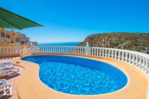 a swimming pool on a balcony with the ocean in the background at Villa Octavio by Abahana Villas in Benitachell