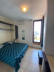 een slaapkamer met een bed en een groot raam bij Hotel Normanni in Praia a Mare