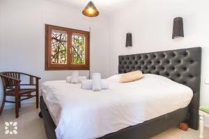 a bedroom with a large bed and a chair at Villa Octavio by Abahana Villas in Benitachell