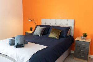 een slaapkamer met een groot bed met een oranje muur bij Shelen View in Saint Helens