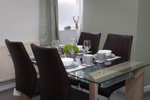 a dining room table with black chairs and a glass table and chairsktop at Shelen View in Saint Helens