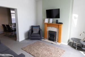 a living room with a fireplace and a chair and a television at Shelen View in Saint Helens