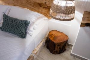 a bedroom with a bed with a wooden log on it at ONAR LUXURIES in Ermoupoli