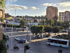 uma cidade com um ônibus e carros em uma rua em Centre-ville appartement em El Jadida