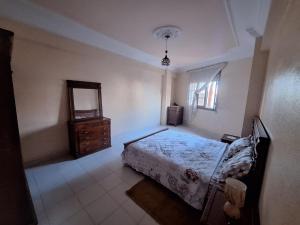 um quarto com uma cama, uma cómoda e um espelho em Centre-ville appartement em El Jadida