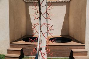 a fire pit in a building with red branches at Artishow in LʼIsle-sur-la-Sorgue