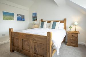 1 dormitorio con cama de madera con sábanas y almohadas blancas en Fairview 2 en Ampleforth