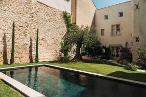 a swimming pool in a yard next to a building at Artishow in LʼIsle-sur-la-Sorgue