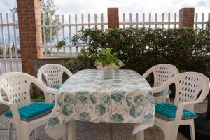 une table avec quatre chaises et un vase sur elle dans l'établissement Da Nonna Tina VistaMare, à Piombino