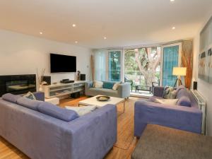 sala de estar con 2 sofás azules y TV en 5 Red Sails en Poole
