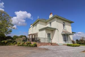 una gran casa blanca con techo en Buckland House en Taunton