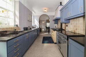 cocina grande con armarios y electrodomésticos azules en Buckland House, en Taunton