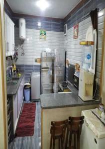 a kitchen with a counter and two chairs in it at فيلا رائعه في الساحل الشمالي مارينا 6 اطلاله بحر in El Alamein